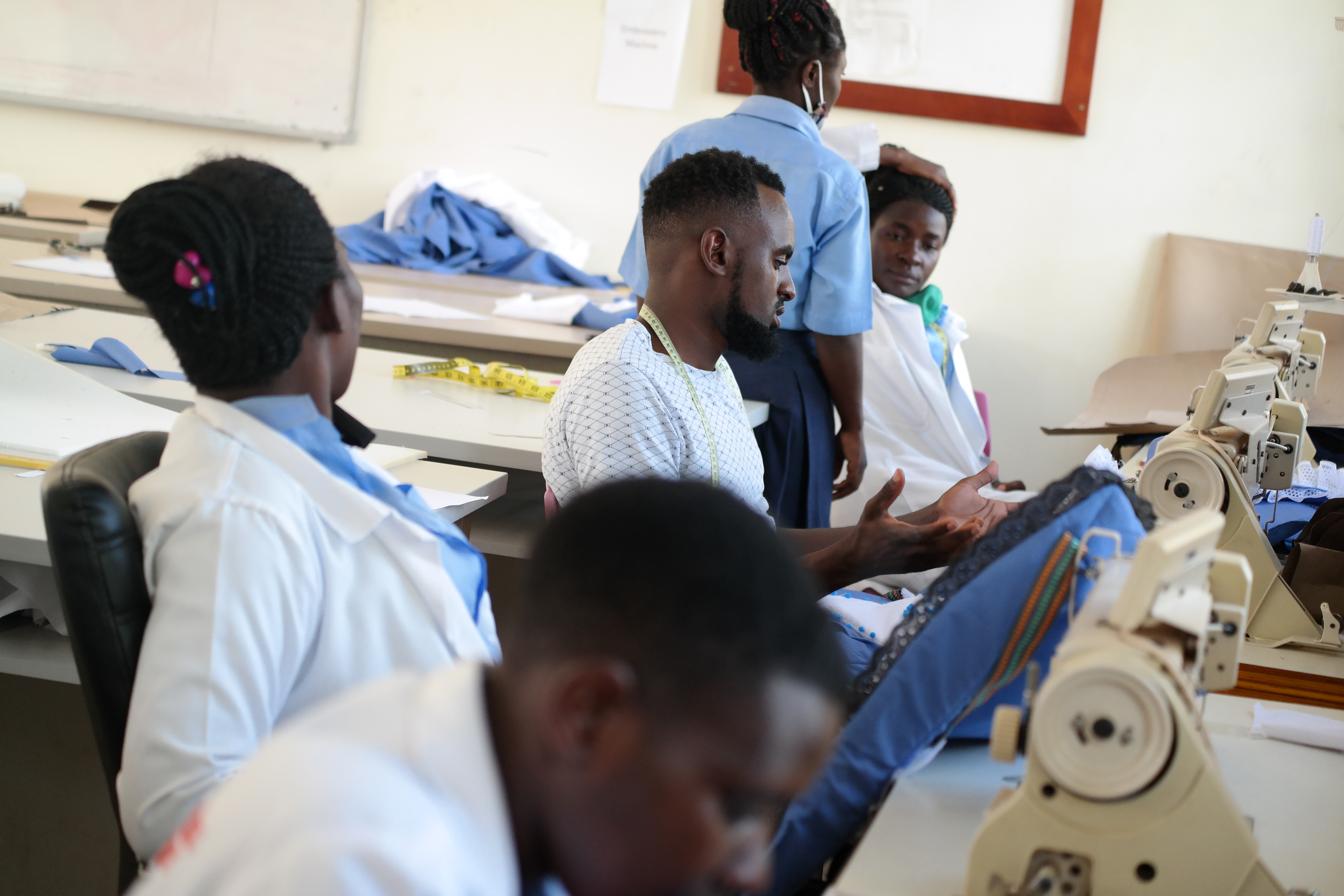 Students learning sewing machine operation at St. Peter's VTI Mubende
